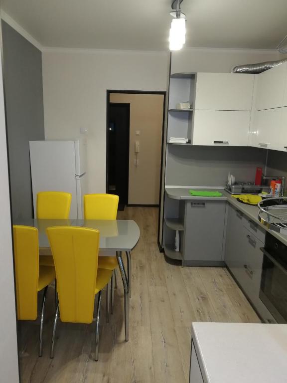 エッセントゥキにあるНовопятигорская 6のキッチン(テーブル、黄色い椅子付)