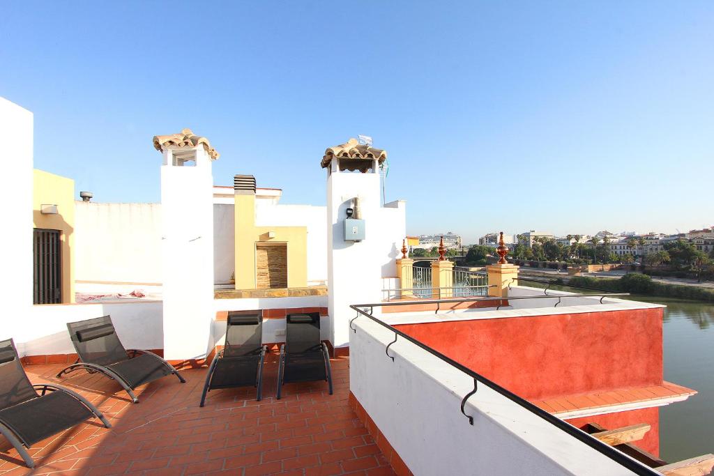 balcón con sillas y vistas al agua en Veoapartment Casa Betis, en Sevilla