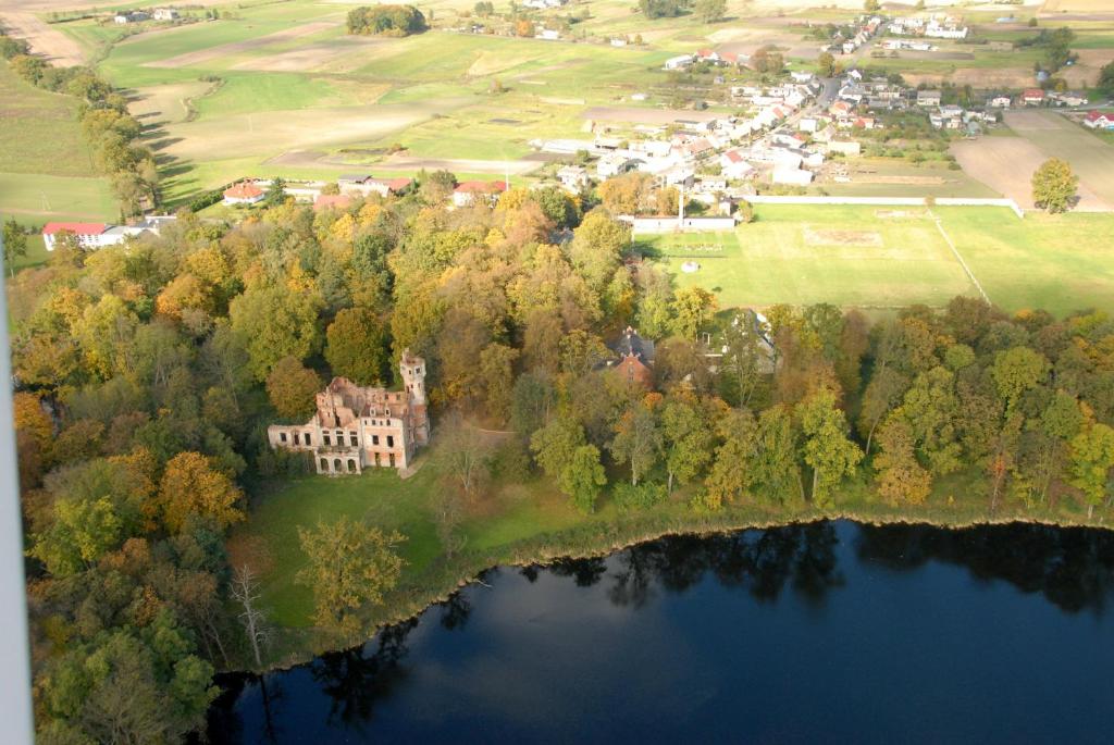 eine Luftansicht eines Hauses auf einer Insel in einem See in der Unterkunft Pałac Runowo in Runowo Krajeńskie