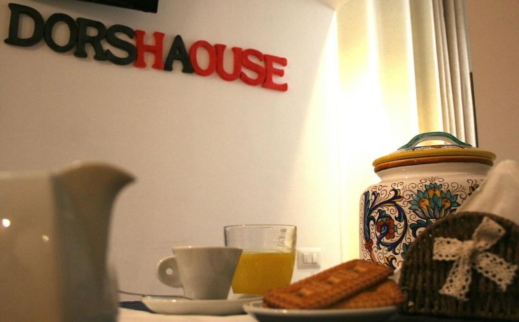 a table with a vase and a plate of cookies and orange juice at dorshaouse in Civitavecchia