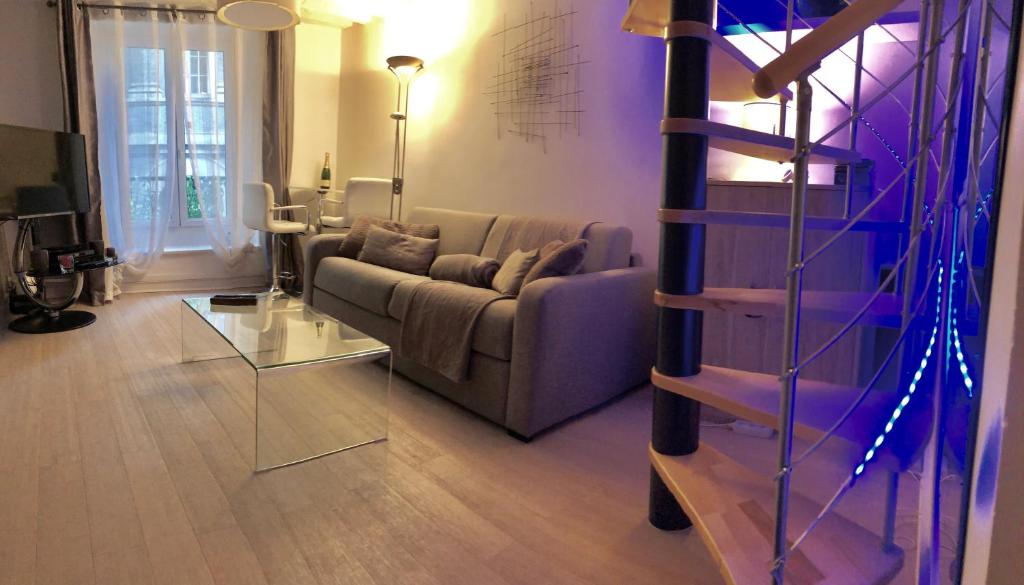 un salon avec un canapé et une table en verre dans l'établissement Apartment Duplex Paris, à Paris