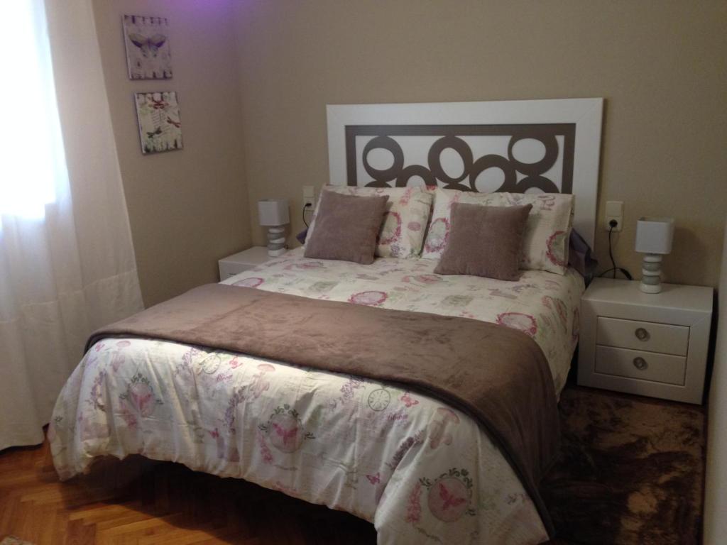 a bedroom with a large bed and two night stands at Apartamento Homelife Buenavista 2 in Toledo