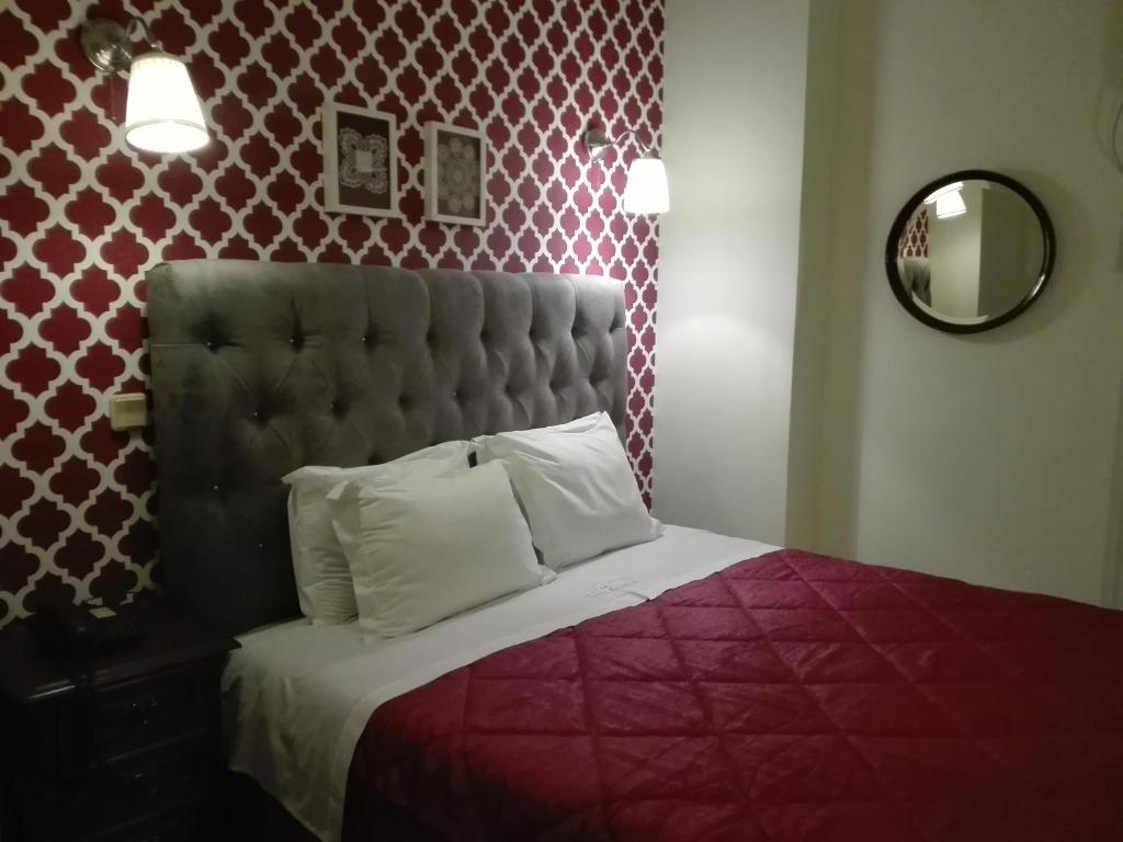 um quarto com uma cama com um edredão vermelho em Hotel Kamanga em Tomar