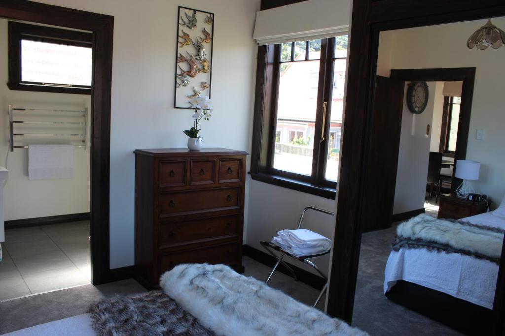 a bedroom with a mirror and a dresser and a bed at Casa Felina Apartment in Wellington