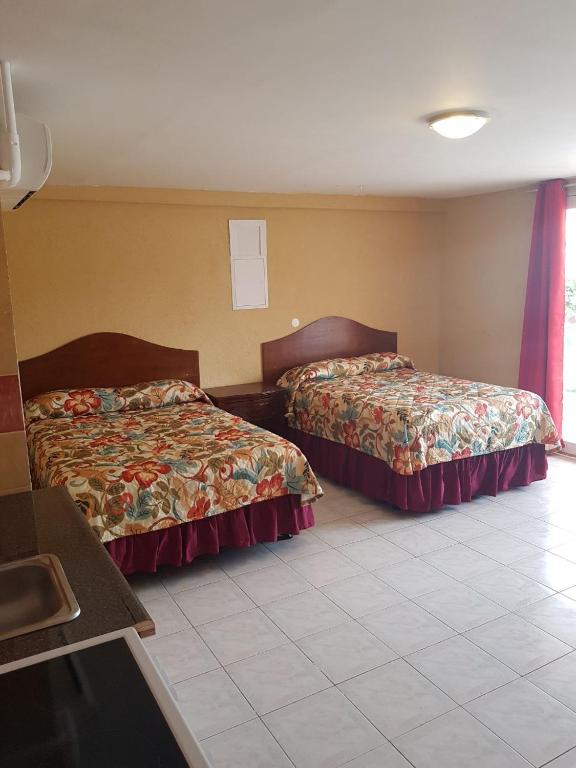 a hotel room with two beds and a tile floor at Fantastic Hotel in Marigot