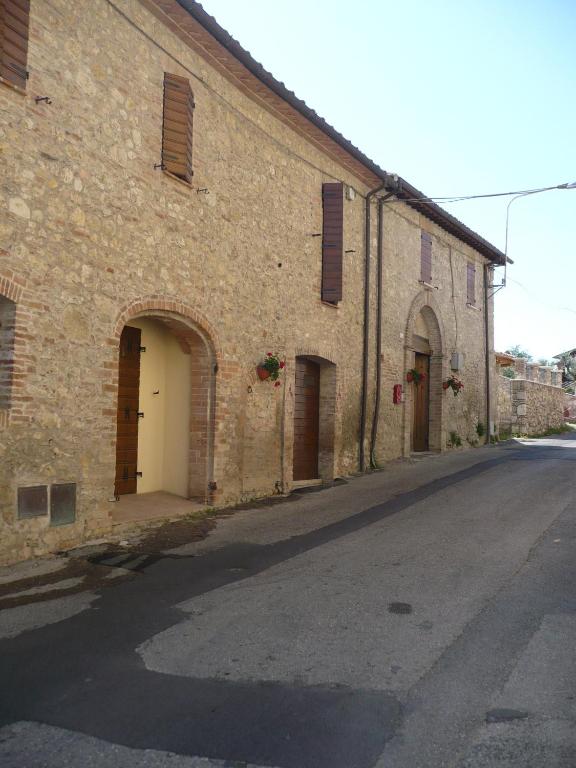 an old brick building with two doors on a street at Agriturismo Piandellerose in Avigliano