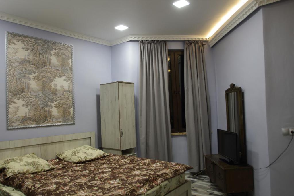 a bedroom with a bed and a television in it at Guesthouse Kato in Tbilisi City
