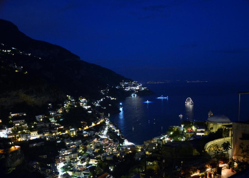 a view of a city at night with the water at La Casarella Apartment Positano in Positano