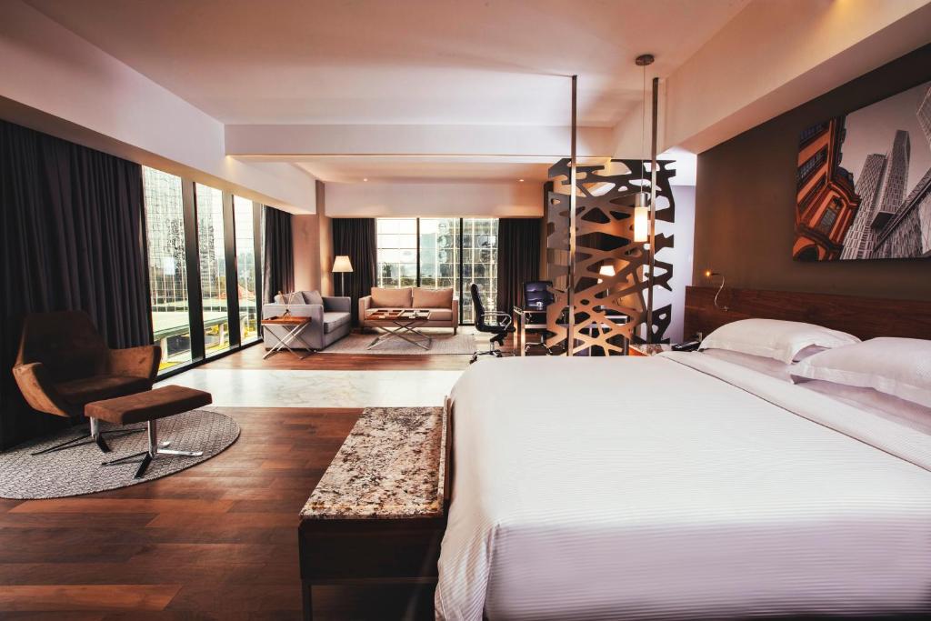 Habitación de hotel con cama y sala de estar. en Krystal Grand Suites Insurgentes, en Ciudad de México