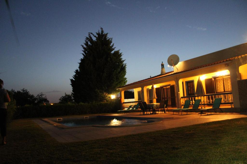 a house with a patio and a pool at night at Casa Joaquina in Carvoeiro