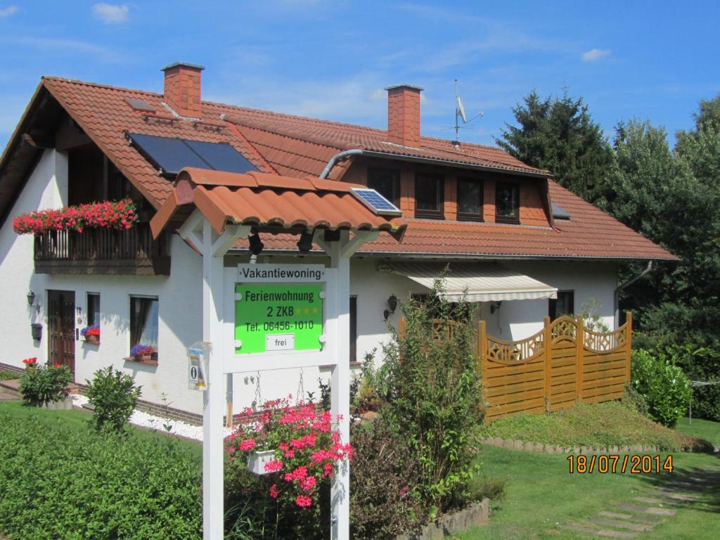 ein Haus mit einem Sonnendach und einem Schild davor in der Unterkunft Ferienwohnung Fackiner in Gemünden an der Wohra