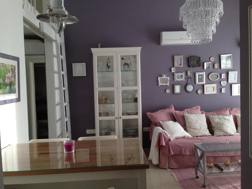 - un salon violet avec un canapé rose et une table en verre dans l'établissement Apartment Vintage, à Orebić