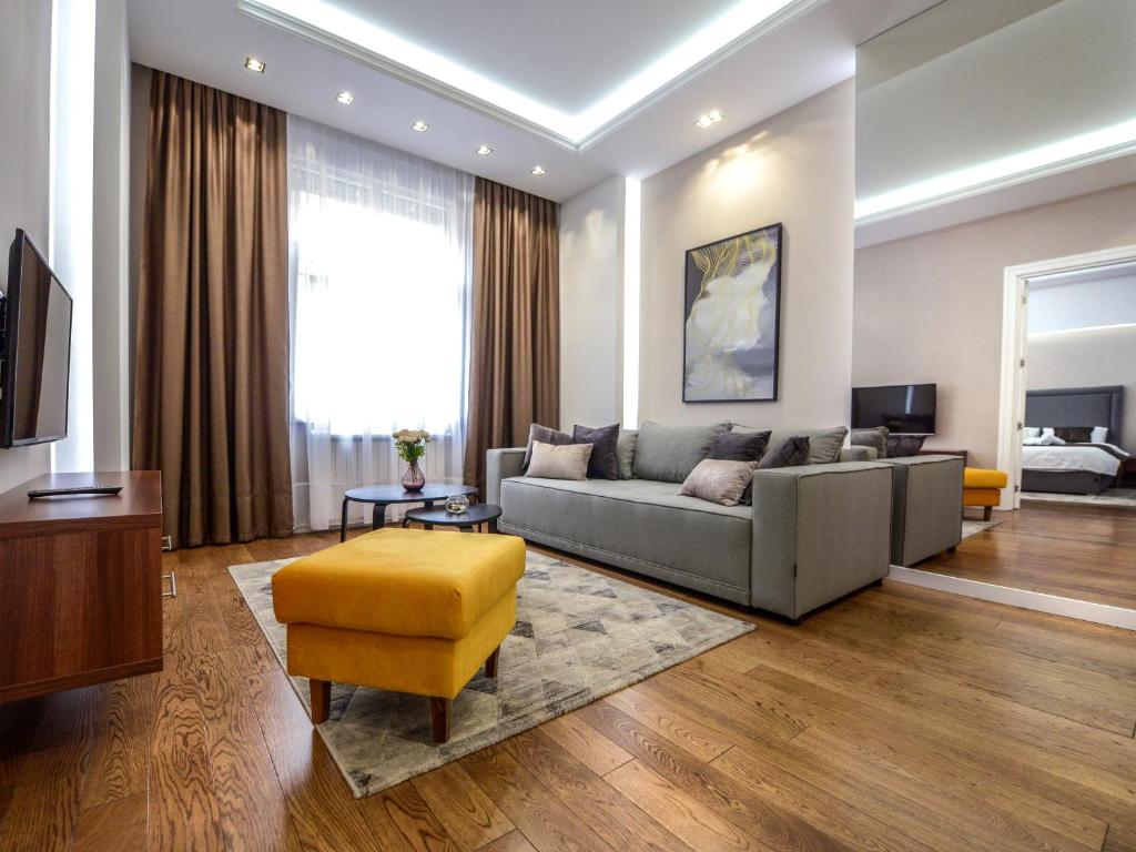 uma sala de estar com um sofá e uma televisão em Main Square Residence em Belgrado