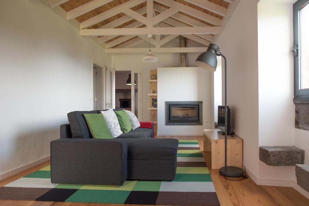 a living room with a couch and a fireplace at Casa do Cedro do Mato in Terra Alta