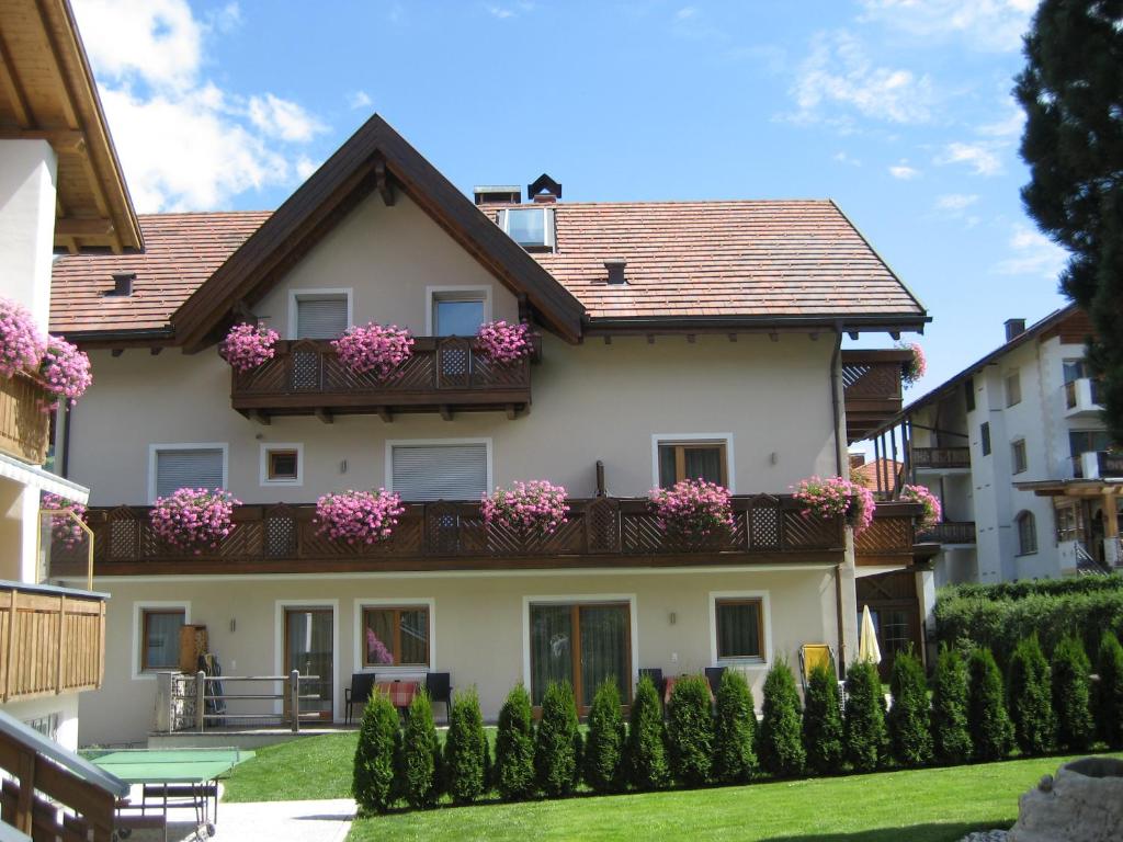 Casa con balcón con flores rosas en Appartements Mutschlechner en Valdaora