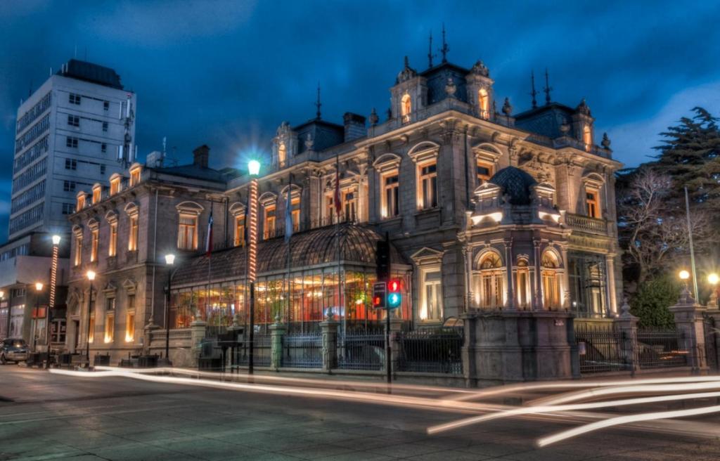 ein altes Gebäude mit einer Ampel davor in der Unterkunft Hotel José Nogueira in Punta Arenas