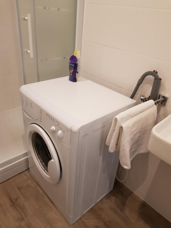 una lavatrice in un bagno con specchio di Logie Rotem a Dilsen-Stokkem