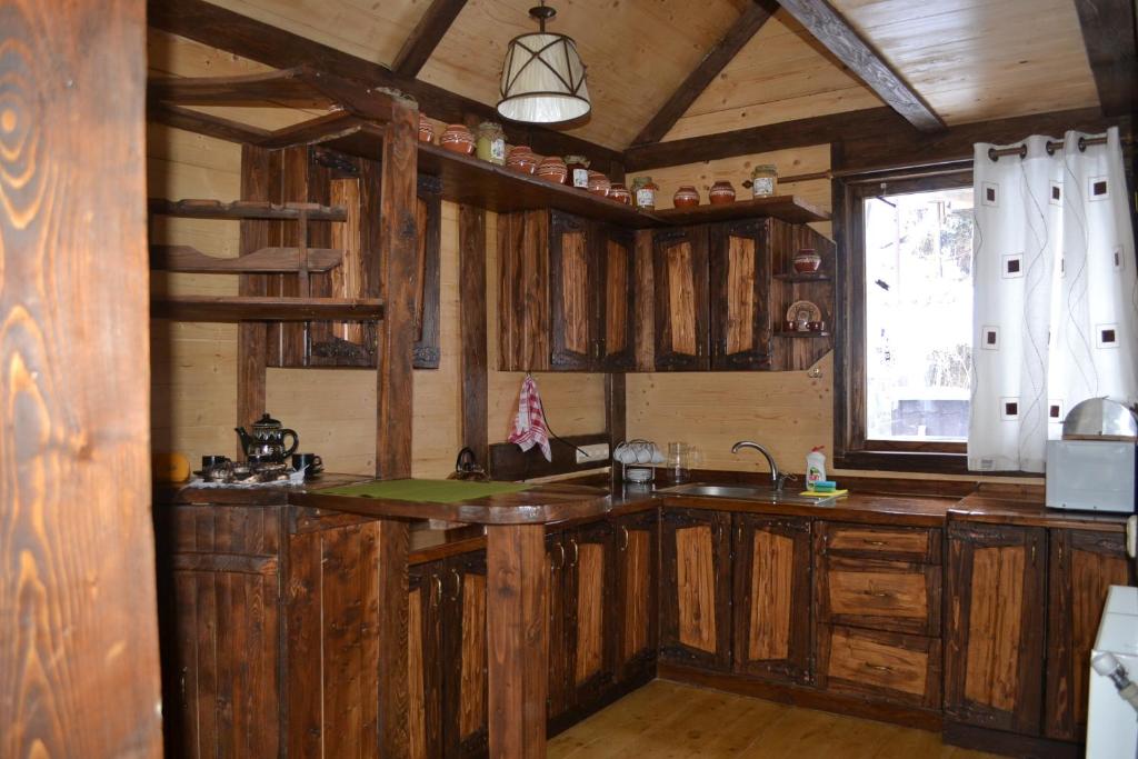 a kitchen with wooden cabinets and a sink and a window at Chalet Shepit Karpat in Bukovel