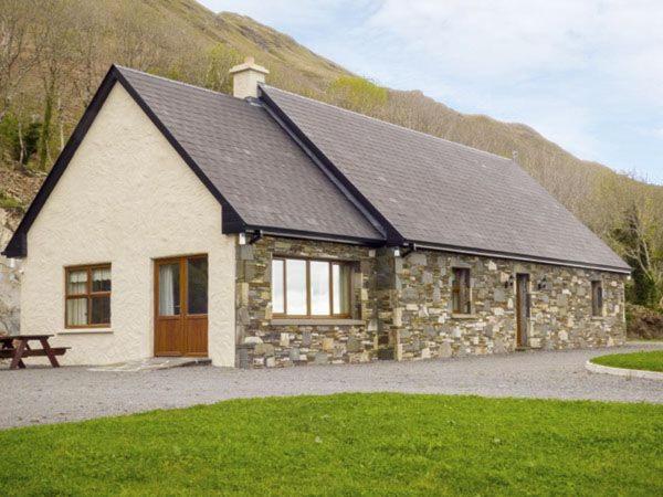 a stone house with a bench in front of it at Maison de Kilbride Finney Clonbur Mayo in Clonbur