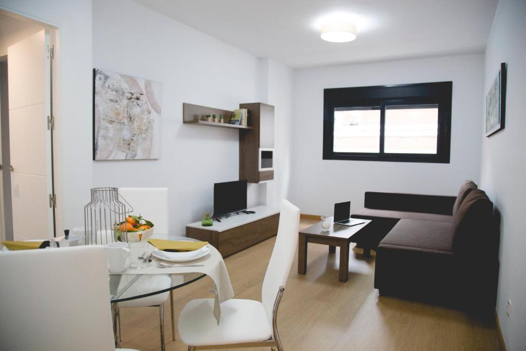 ein Wohnzimmer mit einem Tisch und einem Sofa in der Unterkunft Be Free Granada in Granada