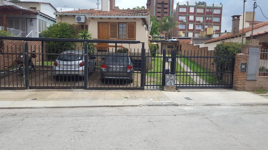 dos autos estacionados frente a una puerta negra en complejo Casa Walter en Villa Carlos Paz