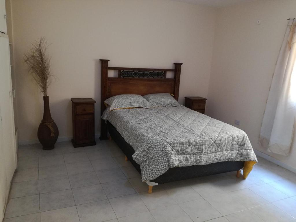 1 dormitorio con 1 cama, 2 mesas y una ventana en MA457 en Mendoza