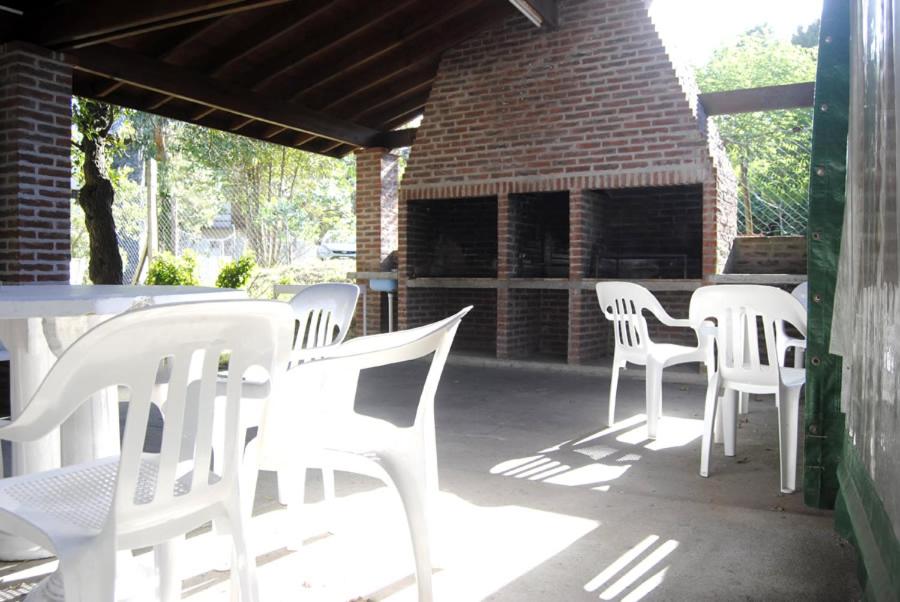 un grupo de sillas y mesas blancas en un patio del Hotel Norte de Villa Gesell