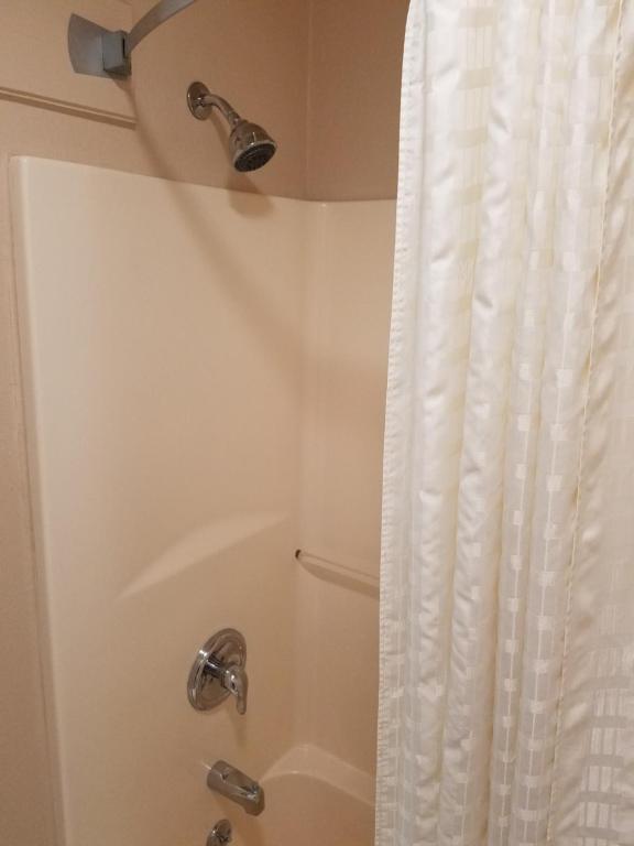 a bathroom with a shower with a shower curtain at Simple Rewards Inn in Guymon