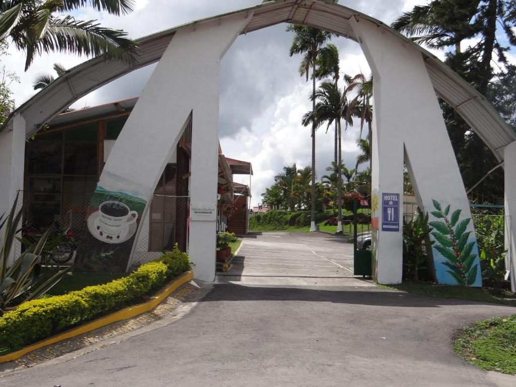 an archway in front of a building with palm trees at Palestina Ecohotel in Chinchiná