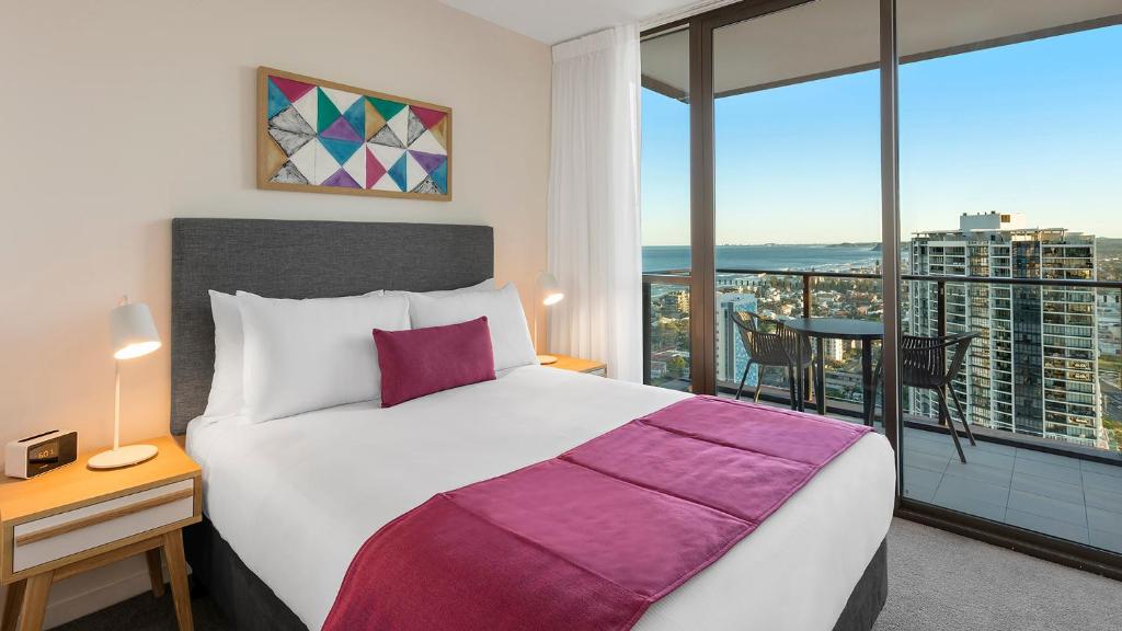 um quarto com uma cama grande e uma janela grande em Avani Broadbeach Residences em Gold Coast