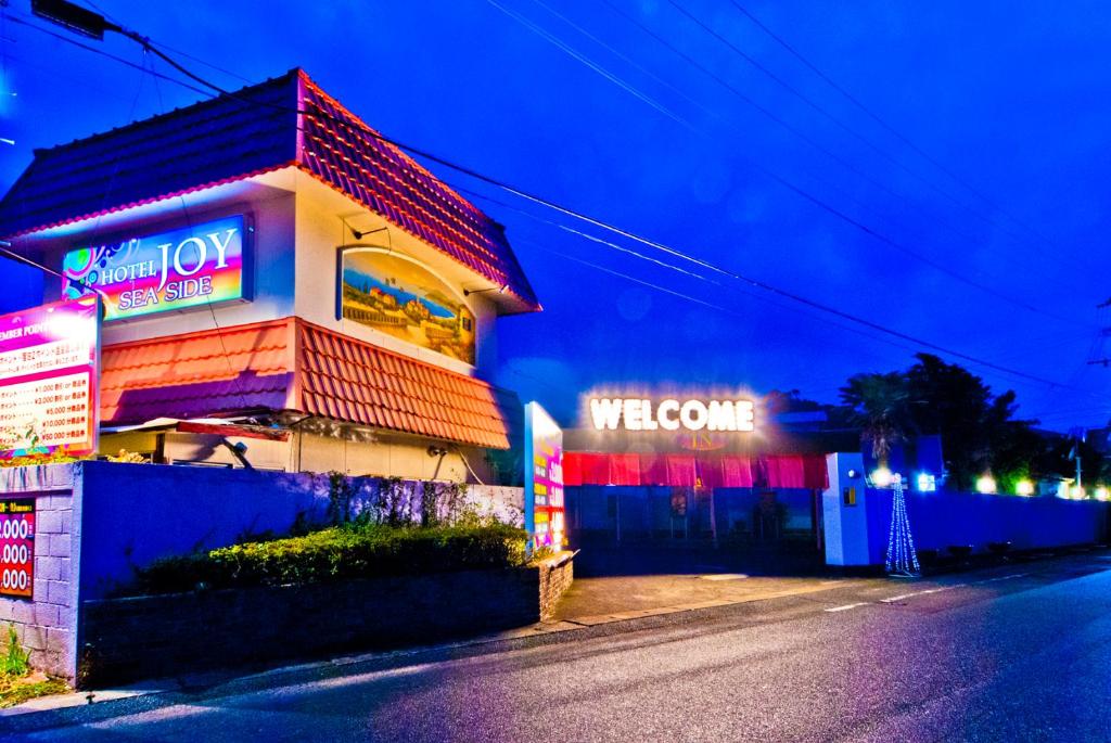 a building with a welcome sign on the side of a street at Hotel Joyseaside (Love Hotel) in Munakata