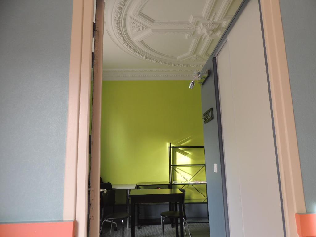 otwarte drzwi do pokoju z zieloną ścianą w obiekcie Appartement Le Gambetta w mieście Le Mans