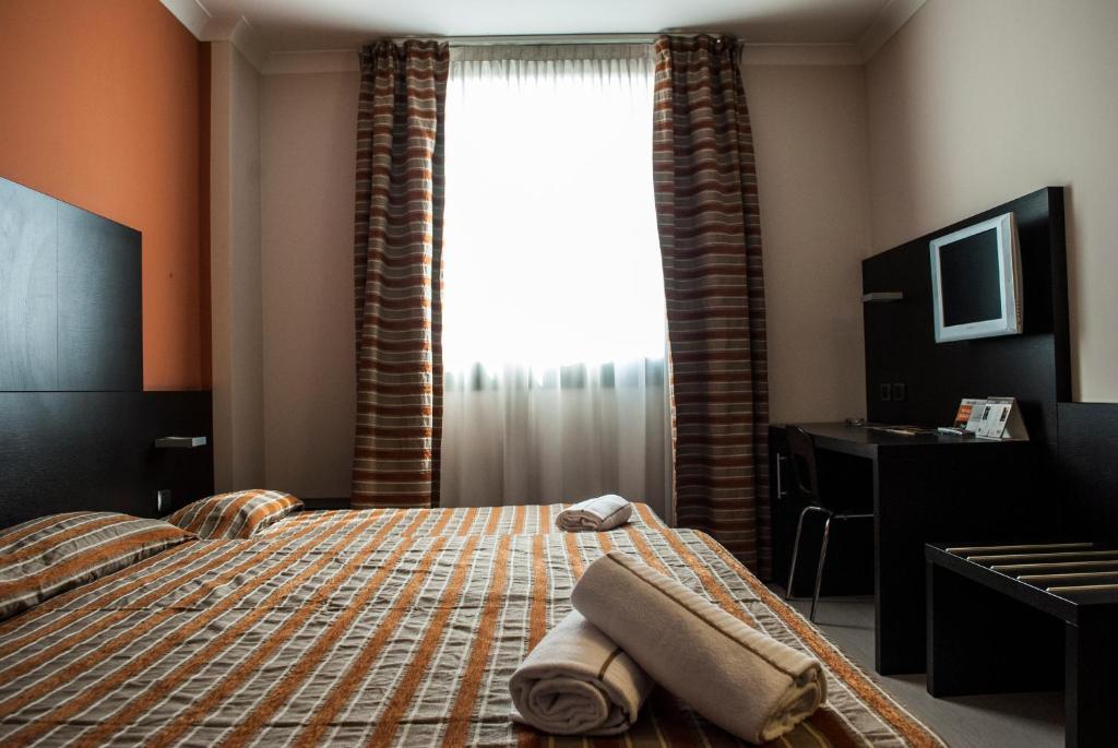Postel nebo postele na pokoji v ubytování Vercelli Palace Hotel