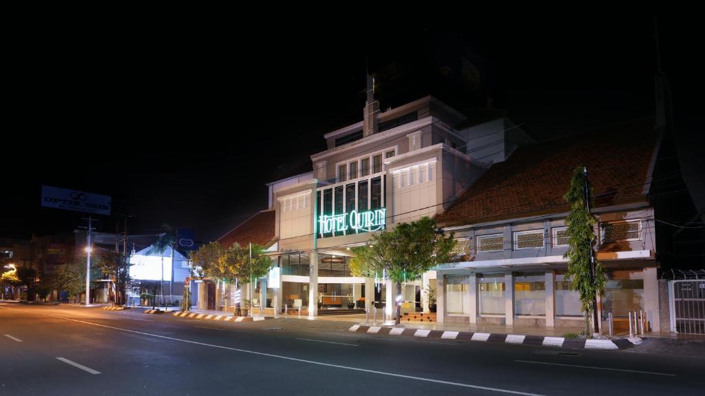 a building with a lit up sign on the side of a street at Hotel Quirin in Semarang