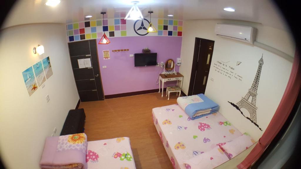 uma sala com um quarto com uma cama e uma televisão em Long Yuan Hotel em Budai