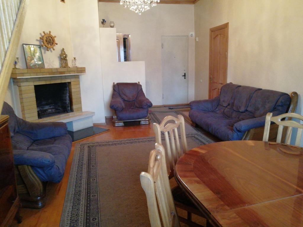 uma sala de estar com uma mesa e cadeiras e uma lareira em Apartment Georgy em Batumi