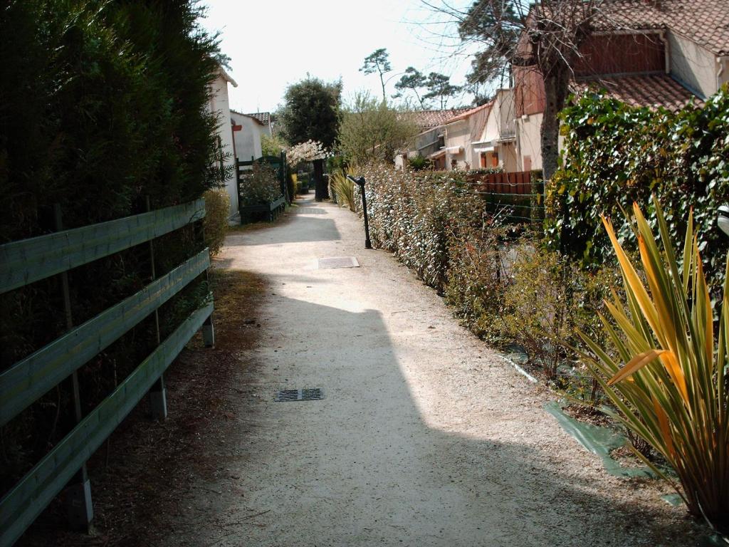 un callejón con una valla al lado de una casa en Les pins ensoleilles, en Saint-Georges-de-Didonne