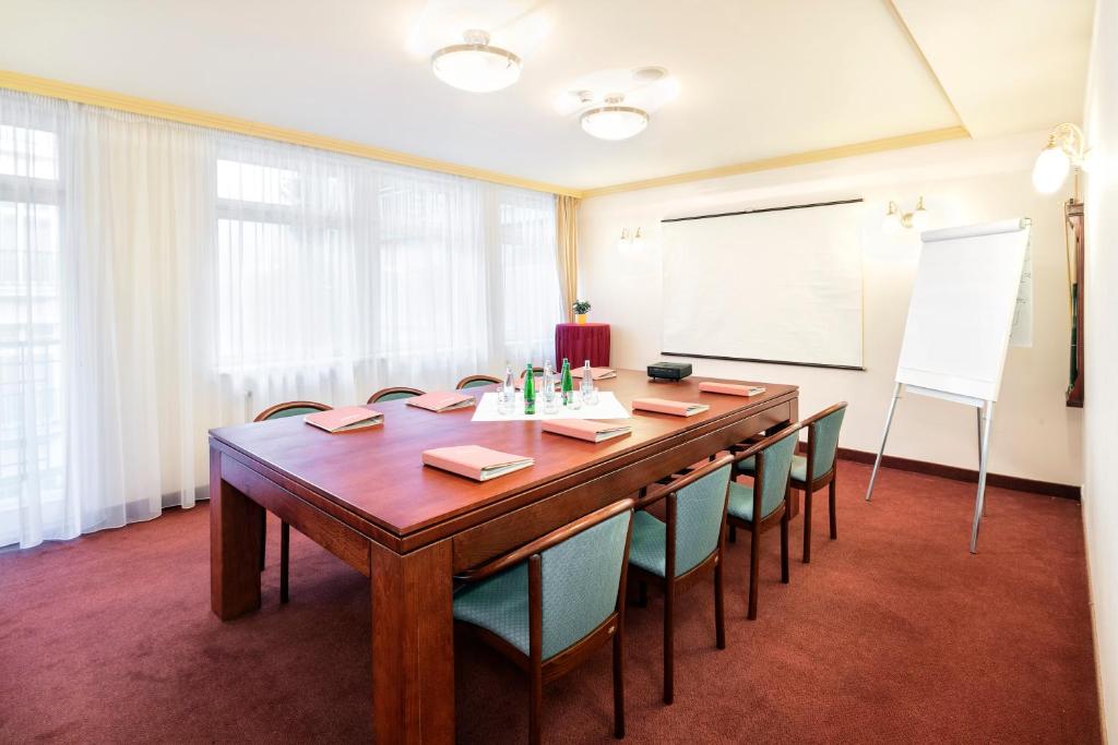 a conference room with a large wooden table and chairs at Interhotel Central in Karlovy Vary