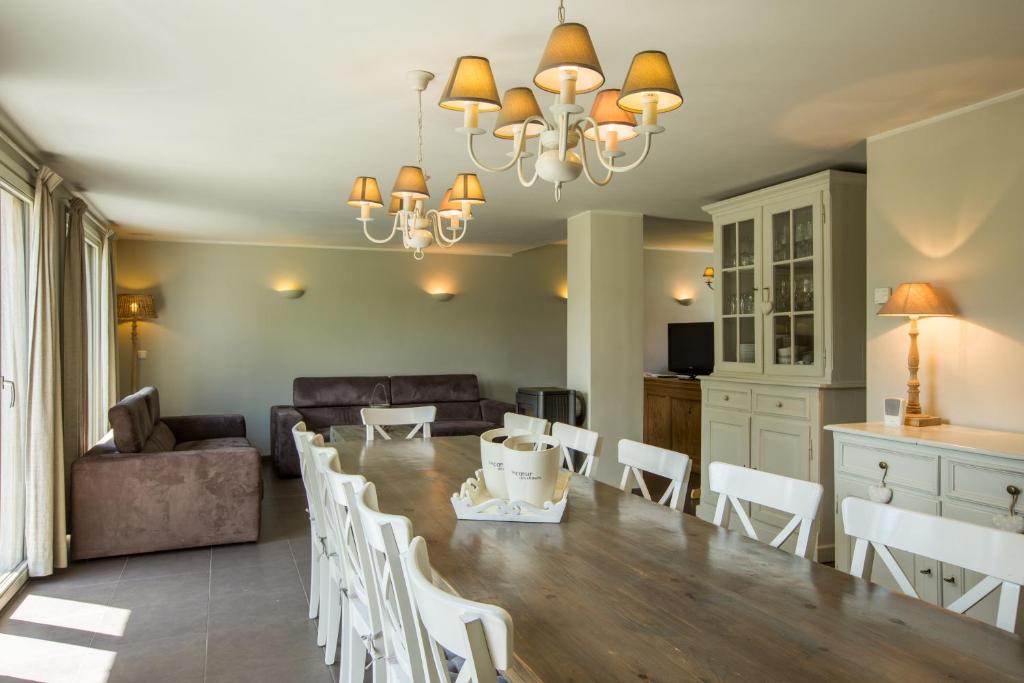 a dining room and living room with a table and chairs at Le Coeur des Choses in Escalles