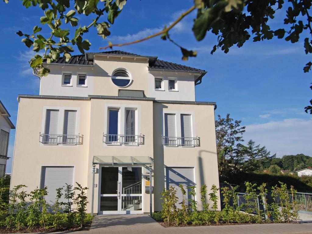 ein weißes Gebäude mit einem runden Fenster in der Unterkunft Haus Möwe - Apt. 013 in Ostseebad Sellin