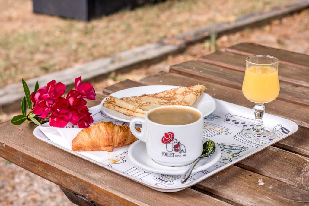 a tray with a cup of coffee and croissants and orange juice at Le Clos des Bruyères in Vallon-Pont-dʼArc