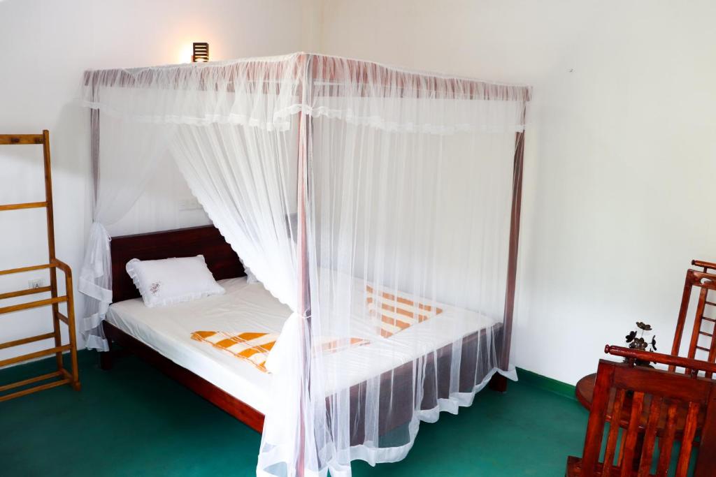 een slaapkamer met een hemelbed bij Nature Home in Mirissa
