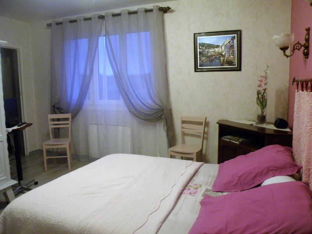 een slaapkamer met een bed met paarse gordijnen en een bureau bij Chambres d'Hotes Le Pavillon du Charme in Cousances-aux-Forges