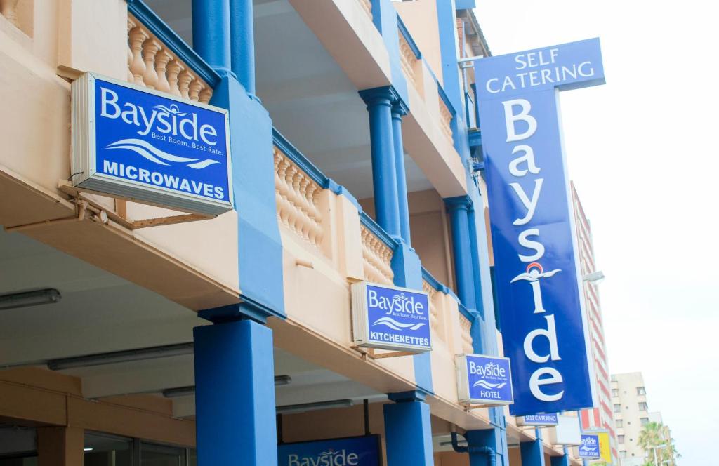 a building with blue signs on the side of it at Bayside Hotel & Self Catering 110 West Street in Durban
