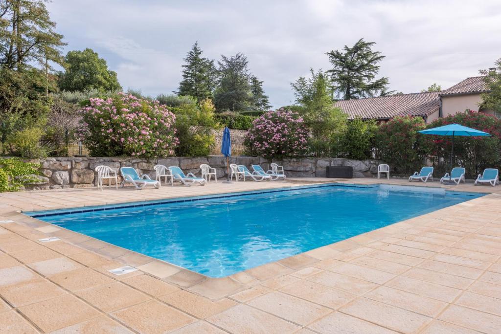 a swimming pool with chairs and an umbrella at Le Clos des Bruyères in Vallon-Pont-dʼArc
