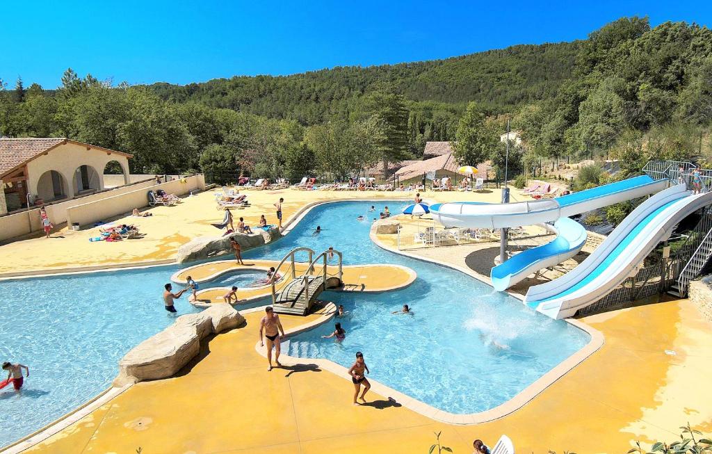 een groep mensen in een zwembad bij een waterpark bij Résidence Odalys Les Hauts de Salavas in Salavas