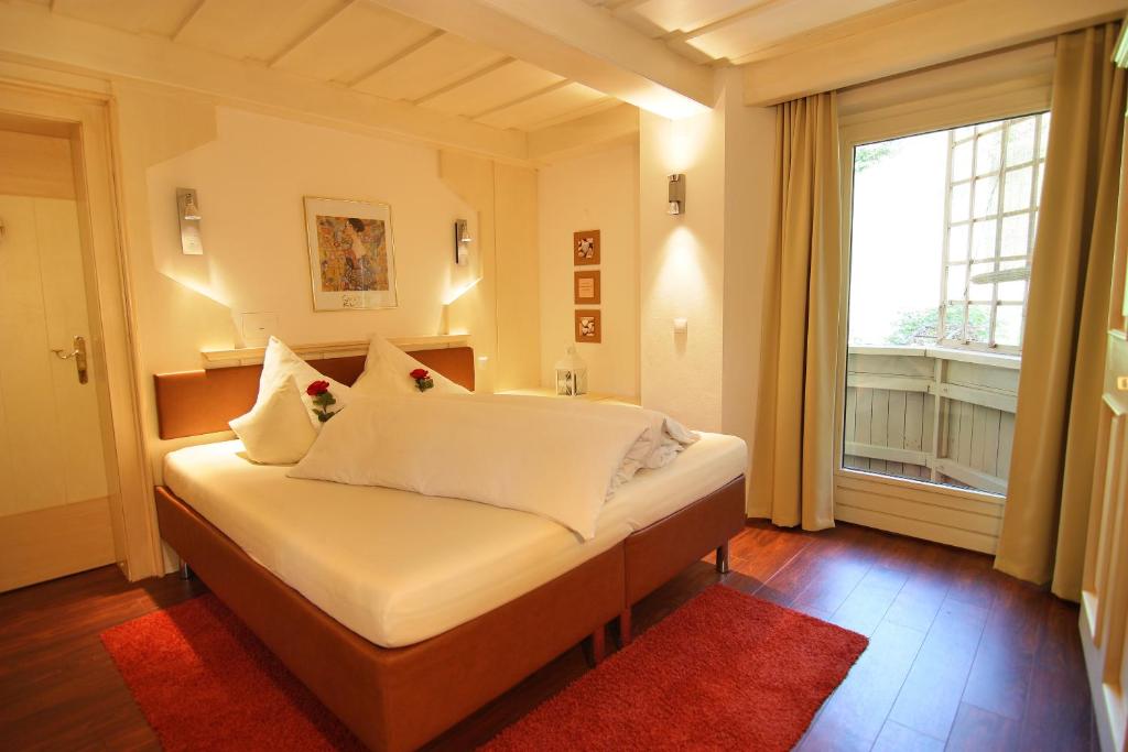 een slaapkamer met een bed met witte lakens en een raam bij Aparthotel Krösbacher in Fulpmes