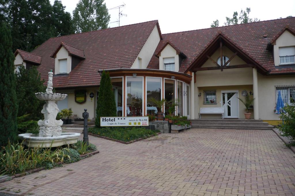 ein Haus mit einem großen Fenster und einer Backsteineinfahrt in der Unterkunft Hotel Sud Alsace in Ranspach-le-Bas