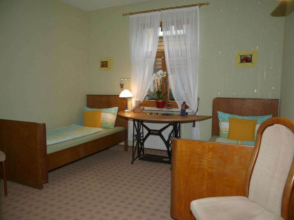 バート・ブランケンブルクにあるFerienwohnung Haus "Anna"のベッド2台、テーブル、デスクが備わる客室です。
