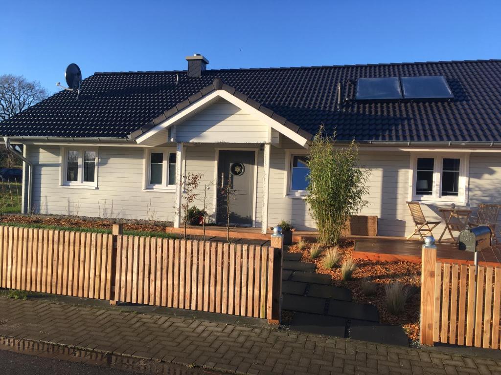 una casa blanca con una valla delante en Schwedenvilla Estelle, en Dörphof